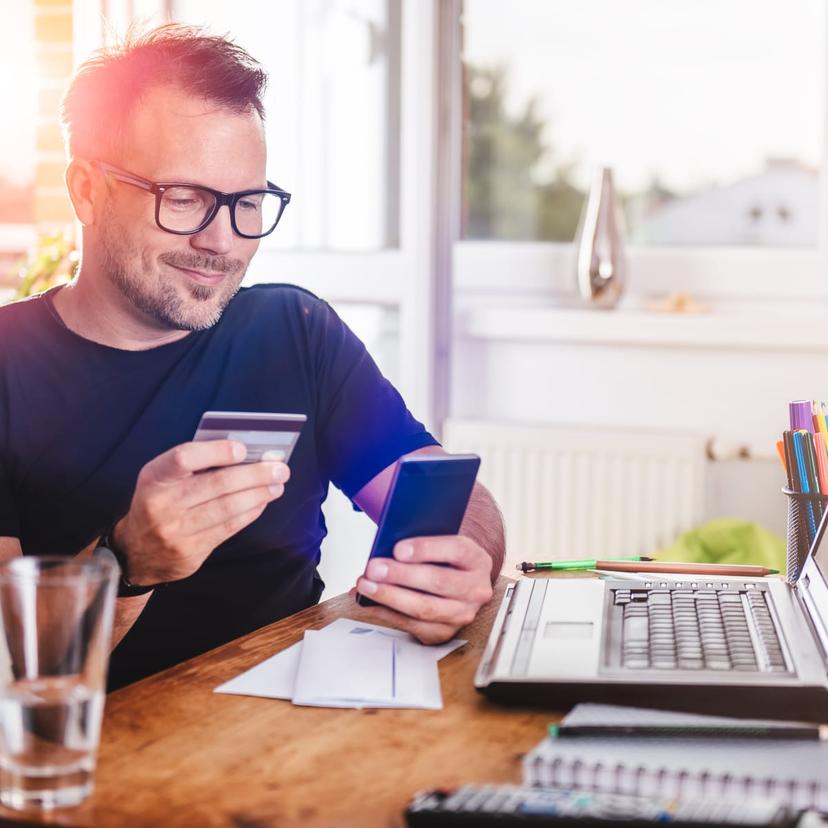 Mężczyzna płaci kartą przez telefon
