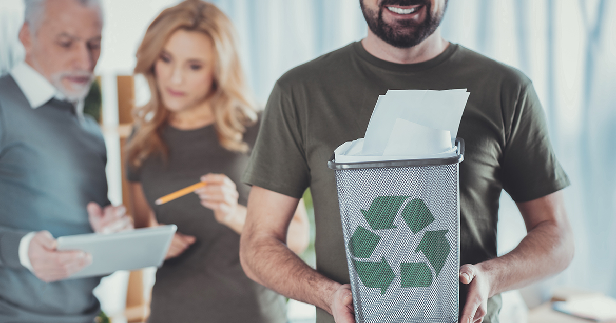 Ekologia w biznesie – mężczyzna trzyma w ręku kosz z materiałami do recyklingu